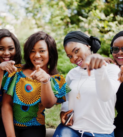 Group of four african american girls sitting outdoor and showing fingers.